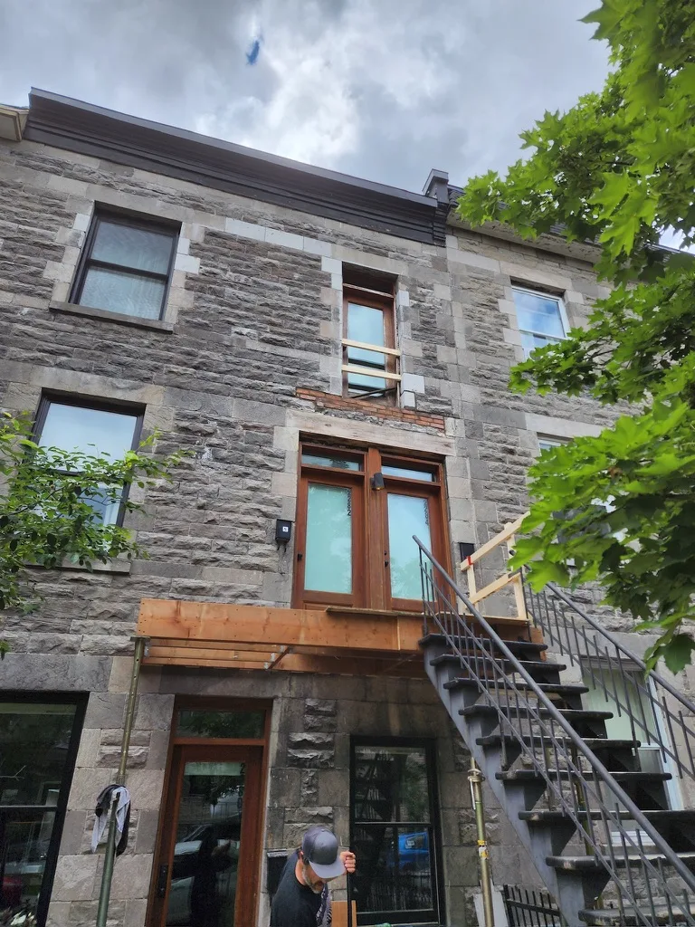 Réfection de balcons superposés Supports en acier, structure bois et soffites avec éclairage intégré. Harmonie parfaite avec la façade en pierre du Plateau Mont-Royal